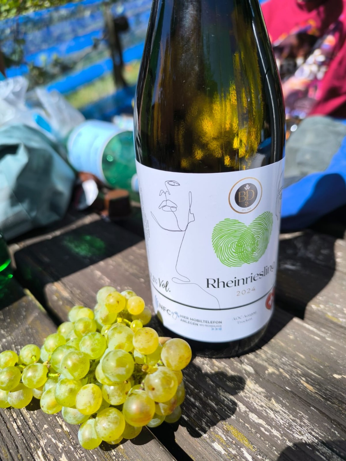 Rheinriesling bottle beside freshly harvested grapes